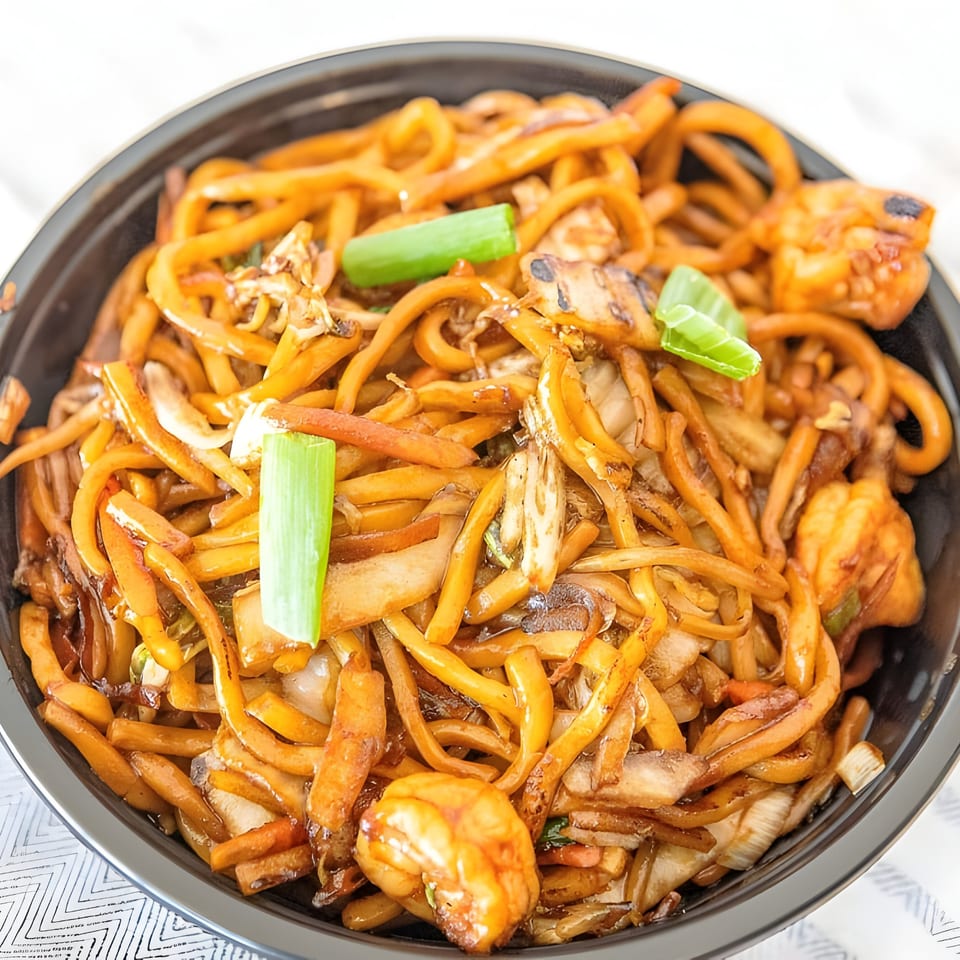 Golden Star's Chinese noodles with shrimp, vegetables, and green onions in a black bowl.